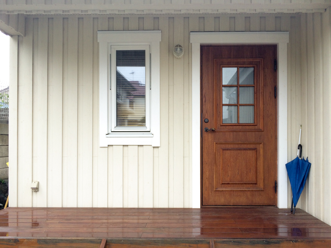 スウェーデンの家、玄関ポーチ。木製玄関ドアと木製3層ガラス窓、板張り外壁。